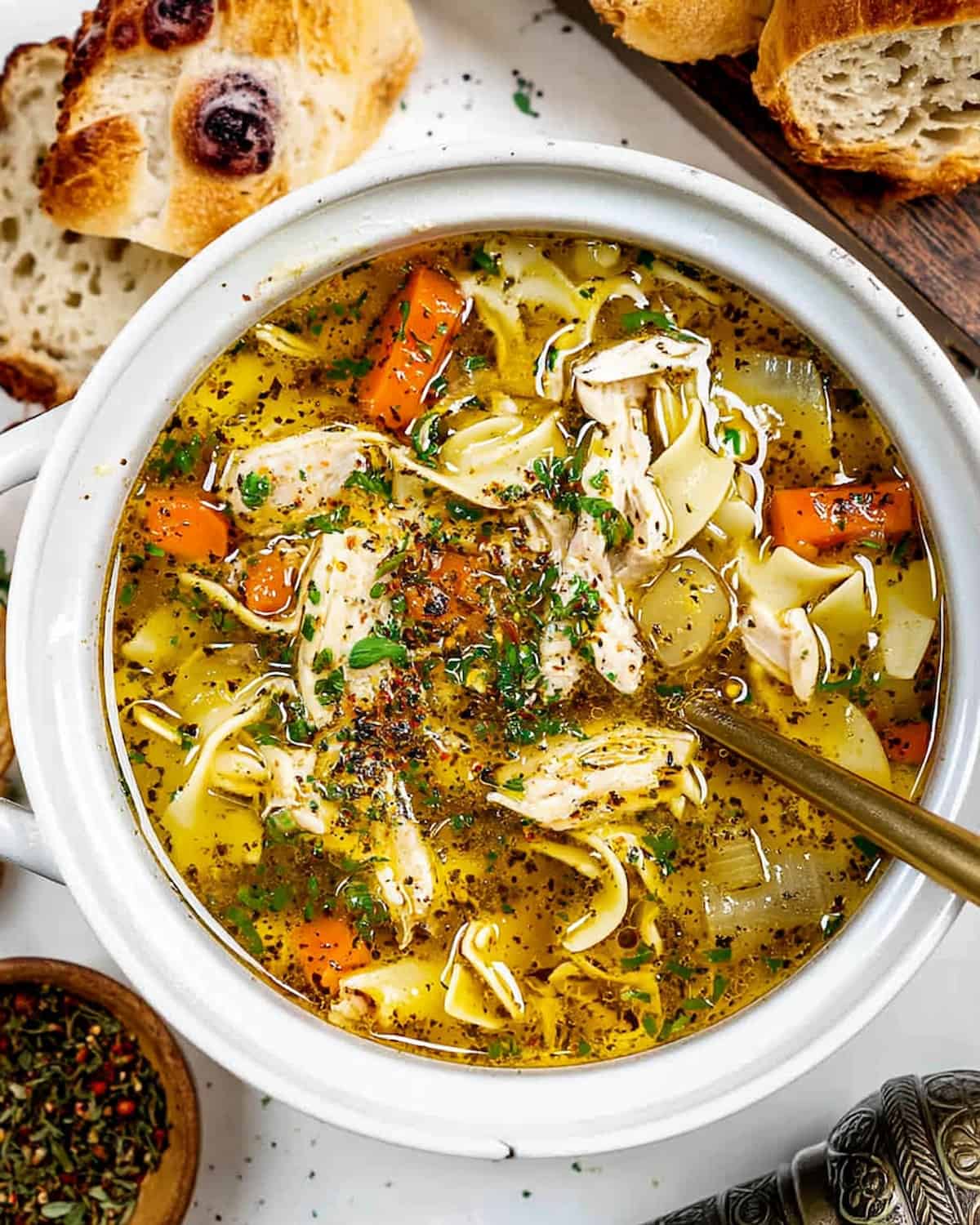 Instant pot chicken breast soup with tender noodles, carrots, onions, and herbs.