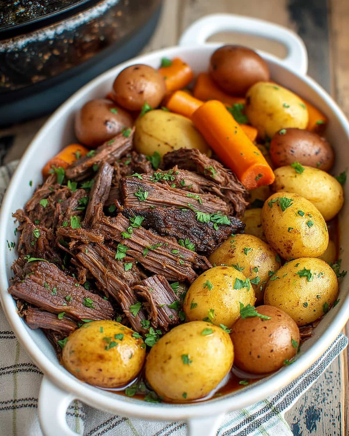 Instant Pot chuck roast with tender baby potatoes, carrots, and fresh herbs.