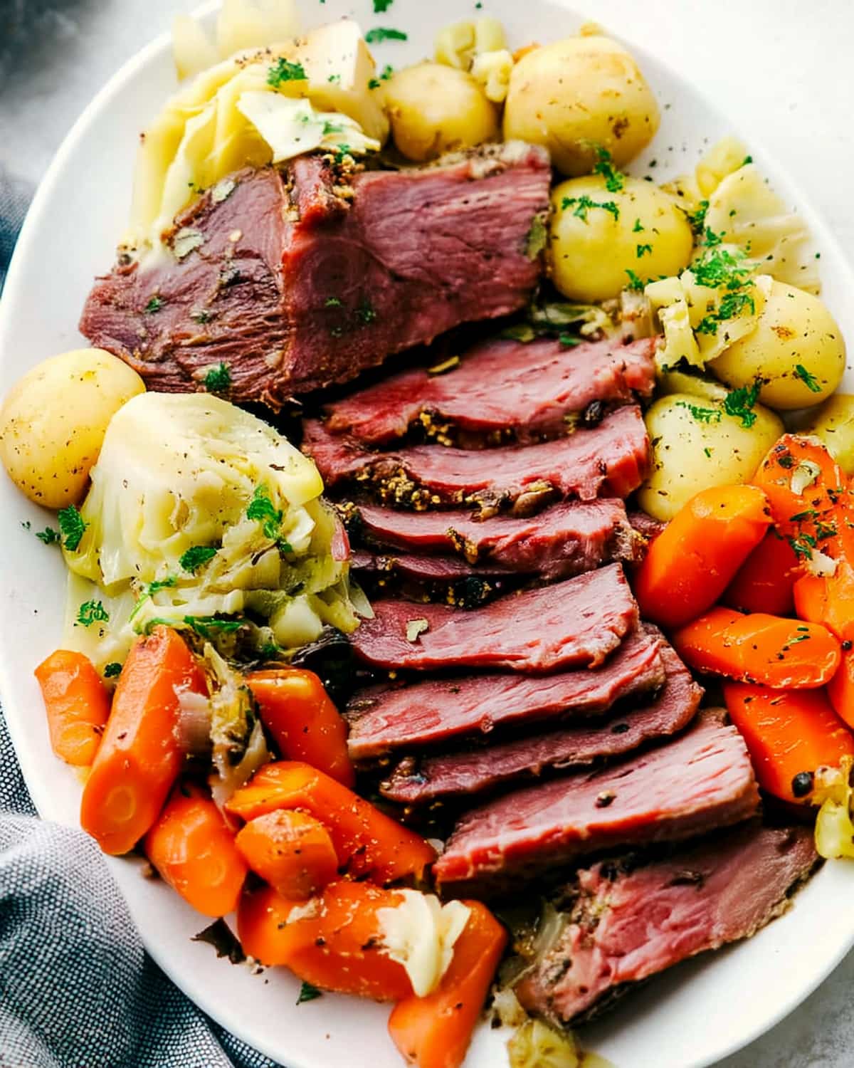 Instant Pot corned beef and cabbage with tender carrots, baby potatoes, and herbs.
