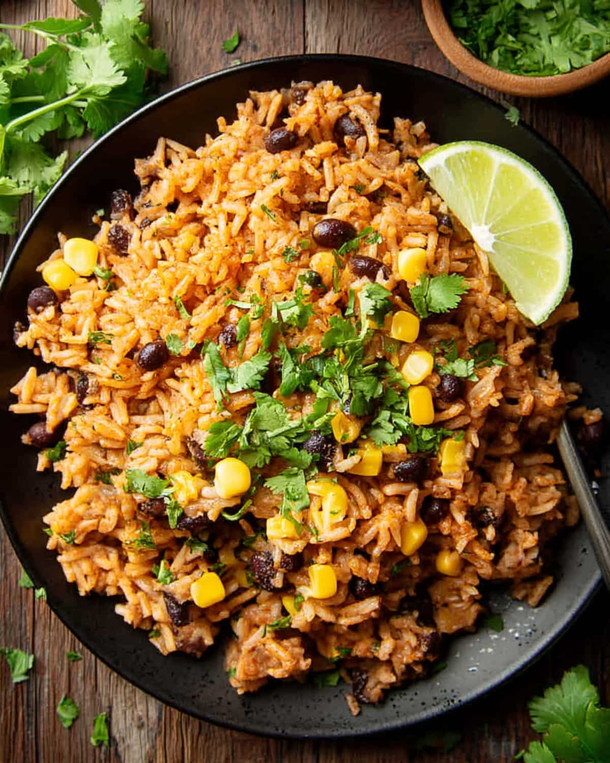 Instant Pot Mexican rice with black beans, corn, and fresh cilantro, garnished with a lime.