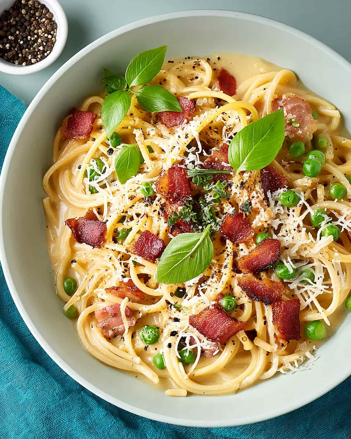 Instant Pot spaghetti carbonara with crispy bacon, green peas, parmesan, and fresh herbs