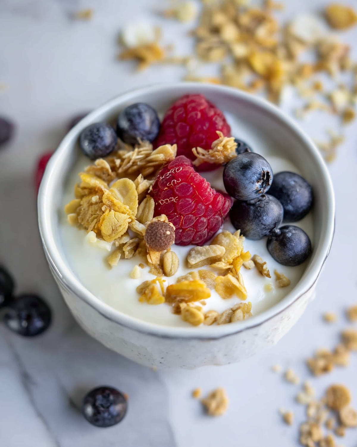 instant pot yogurt recipe topped with fresh blueberries, raspberries, and crunchy granola.