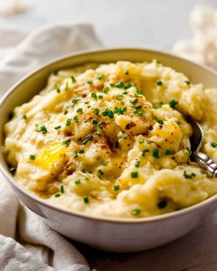 Instant Pot garlic mashed potatoes, topped with melted butter, chopped chives.