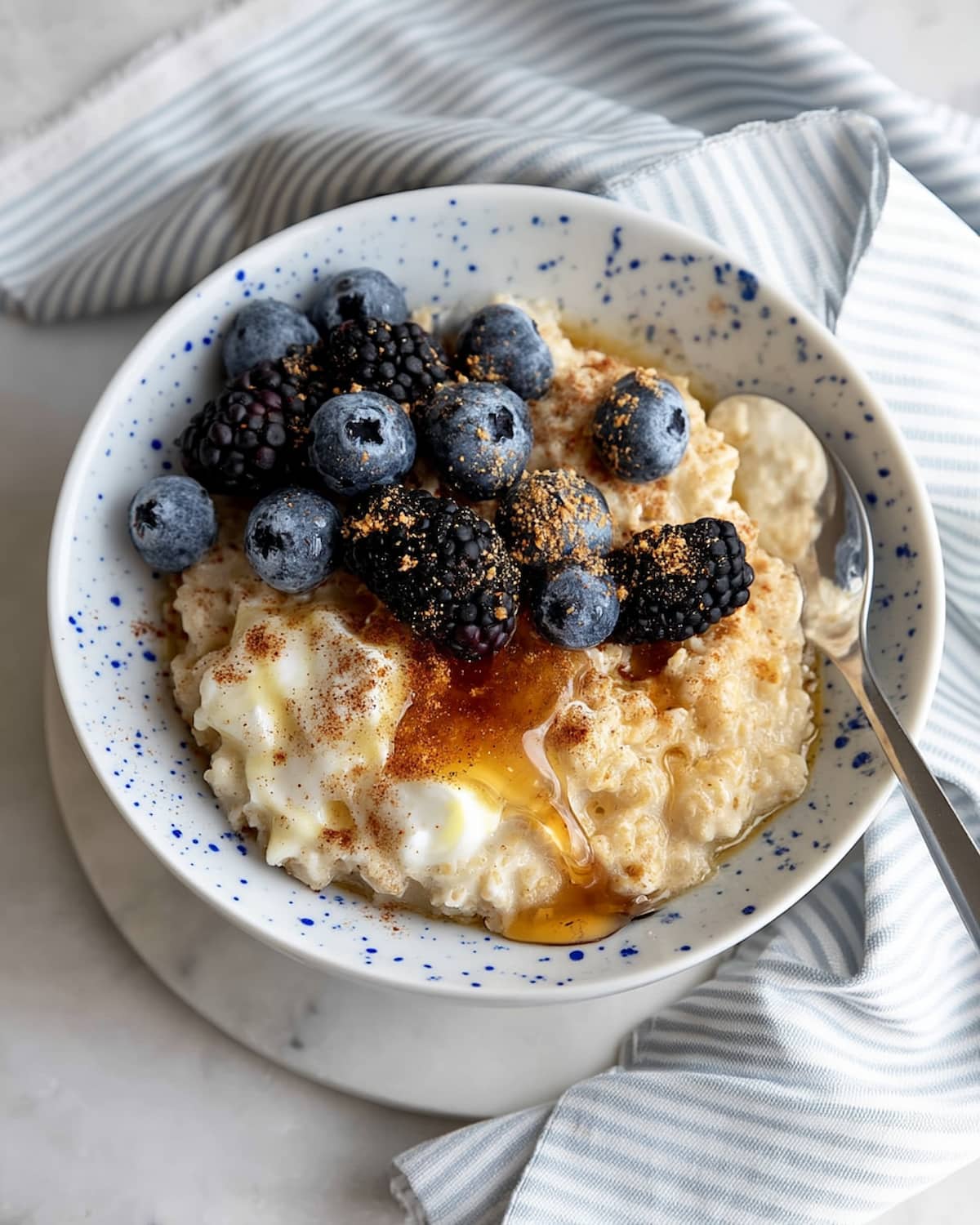 Instant Pot oatmeal topped with fresh blueberries, blackberries, a drizzle of maple syrup, and a sprinkle of cinnamon.
