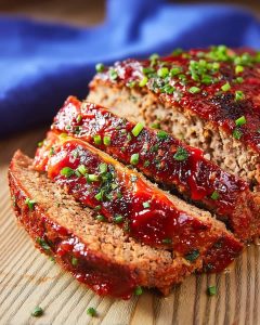 Instant Pot Vegan Meatloaf sliced and glazed with tangy ketchup sauce, topped with fresh herbs.