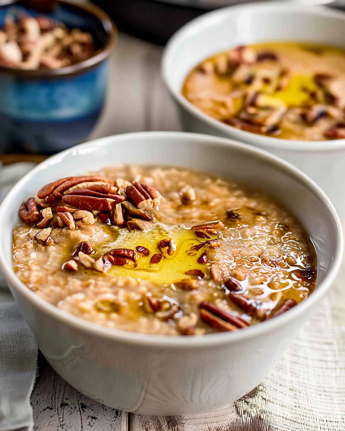Instant Pot Apple Cinnamon Oatmeal topped with chopped pecans and melted butter, served warm in a bowl for a cozy.